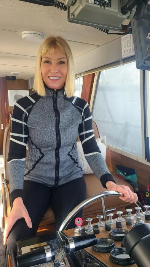 Picture of woman USCG OUPV boat captain at the helm of a boat