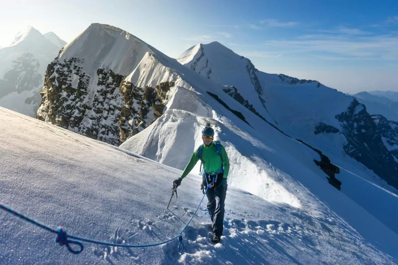 Strong mountaineer standing on summit